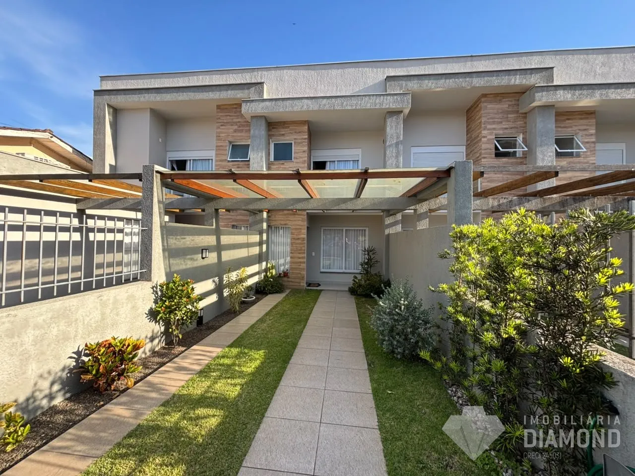 Fachada de um prédio residencial em Lajeado, Brasil, com jardim e varanda.