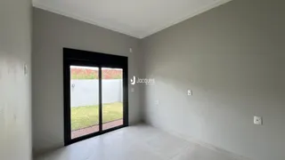 Interior de uma sala com porta de vidro voltada para o jardim.