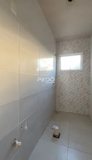 Parede interna com revestimento cerâmico claro em um imóvel.