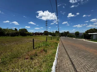 Vista externa de uma área gramada ao lado de uma estrada pavimentada.