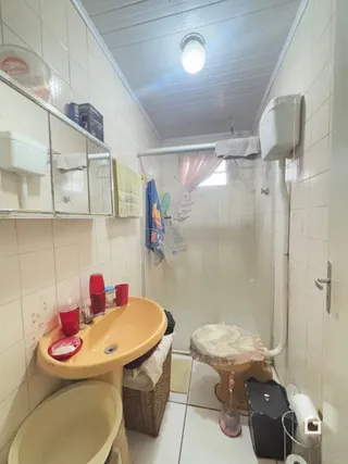 Foto de um banheiro interno com azulejos brancos e bancada de pia.