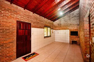 Ambiente interno com paredes de tijolo aparente e piso de cerâmica.
