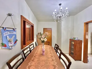 Foto de um ambiente interno com mesa de jantar de madeira e decoração na parede.