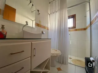 Foto de um banheiro com azulejos brancos e bancada de mármore.