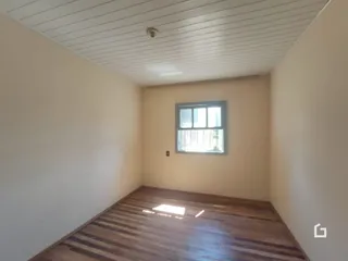 Sala com piso de madeira e teto de painel claro.