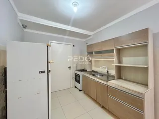 Foto de uma cozinha com armários de madeira clara e piso de cerâmica.