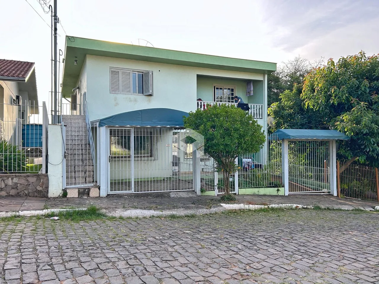 Fachada de uma casa em Lajeado, Brasil com portão e cerca.
