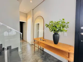 Hall de entrada com piso de cerâmica e bancada de madeira.