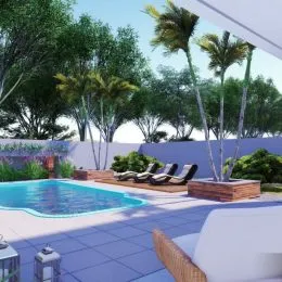 Foto da área da piscina externa com espreguiçadeiras e vegetação tropical.