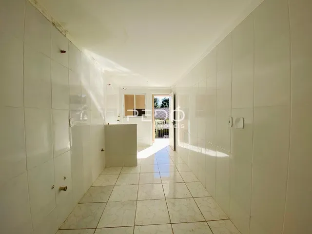 Corredor interno de uma residência com piso de cerâmica clara.