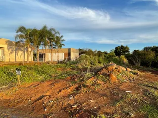 Vista externa da propriedade mostrando vegetação e solo seco na área frontal.