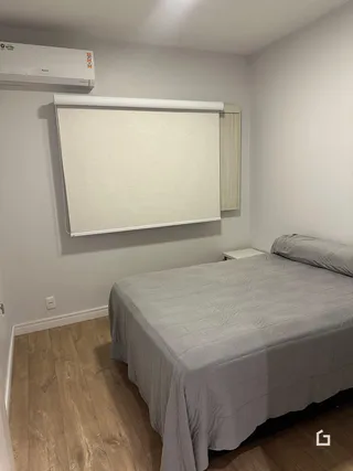 Quarto com cama e janela em ambiente interno.