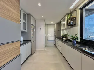 Cozinha moderna com armários e piso claro em um imóvel no Brasil.