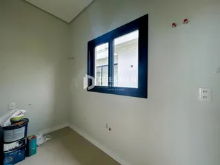 Vista interna de um cômodo com paredes brancas e piso claro.