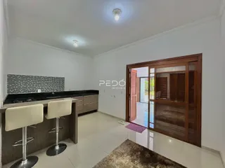 Cozinha moderna com armários escuros e piso de cerâmica clara.