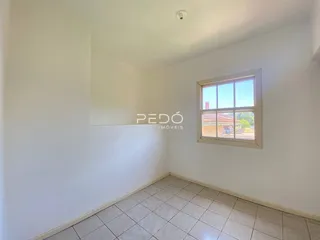 Foto de um cômodo interno com paredes brancas e piso de cerâmica.