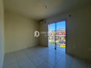 Ambiente interno com piso cerâmico e porta de vidro abrindo para uma área externa.
