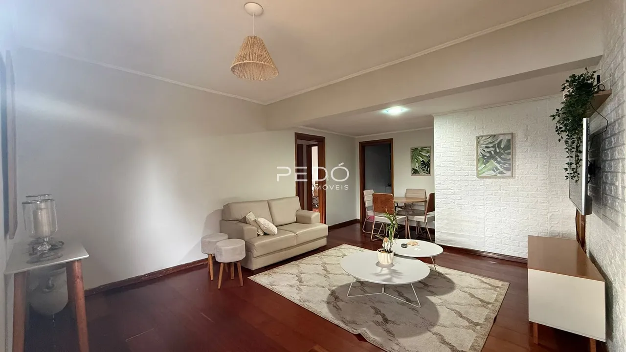 Sala de estar com sofá e piso de madeira.
