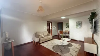Sala de estar com sofá e piso de madeira.