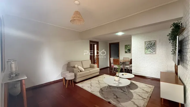Sala de estar com sofá e piso de madeira.