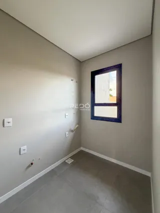 Hall de corredor com paredes claras e piso cinza.