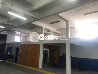 Foto de uma área interna com estrutura de concreto aparente e forro de gesso.