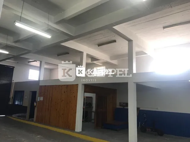 Foto de uma área interna com estrutura de concreto aparente e forro de gesso.