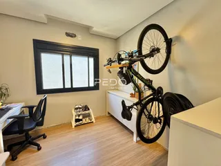 Quarto com piso de madeira e grande janela.