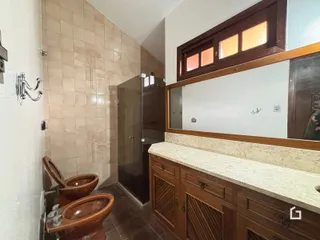 Foto de um banheiro com revestimento de azulejos e bancada de madeira.