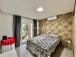 Quarto com cama e porta de vidro abrindo para o exterior.