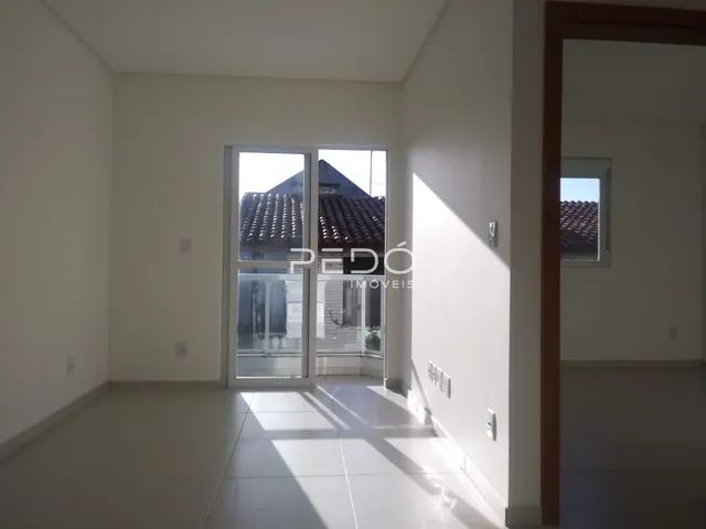 Interior de um ambiente com piso claro e portas de vidro.