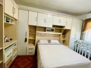 Quarto com armários brancos e cabeceira de madeira.