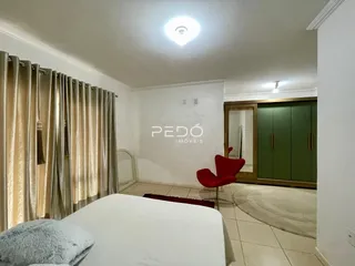 Quarto com cama e cortinas douradas na sala.