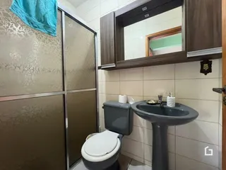 Foto de um banheiro com azulejos claros e um vaso sanitário.