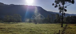 Paisagem de campo aberto com colinas ao fundo.