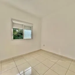 Vista interna de um cômodo com piso de cerâmica e janela.