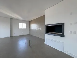 Sala ampla com piso de concreto e paredes brancas em imóvel no Lajeado.