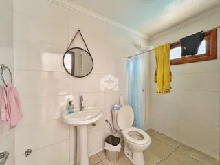 Banheiro com paredes brancas e piso de cerâmica