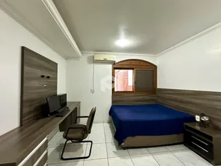 Quarto com cama e armário de madeira na residência.