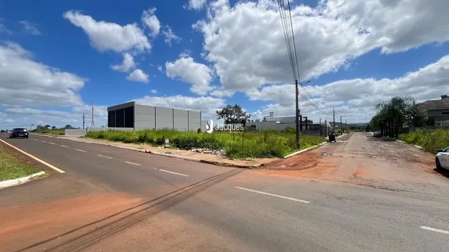 Vista da propriedade com uma estrada e vegetação ao fundo.