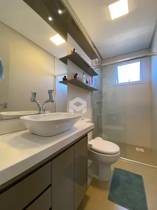 Banheiro moderno com bancada dupla e louças brancas.