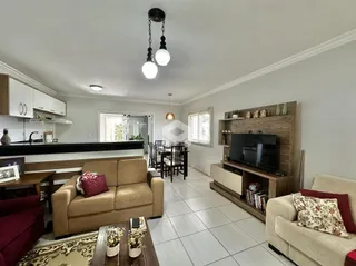 Sala de estar com cozinha integrada e área de jantar em um imóvel no Brasil.