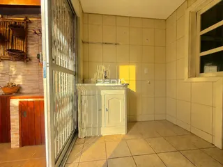 Interior de um corredor com paredes de azulejo claro e piso de cerâmica.