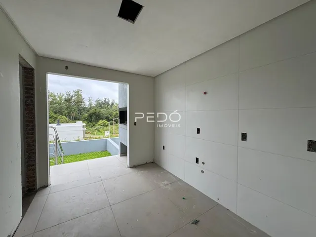 Espaço interno com parede de tijolo e abertura para o exterior.