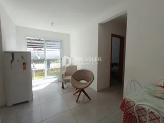 Sala de estar iluminada com porta de vidro abrindo para o exterior.