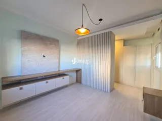 Ambiente interno com piso claro e bancada de madeira na sala.