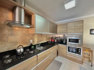 Cozinha moderna com armários de madeira e eletrodomésticos de aço inoxidável.