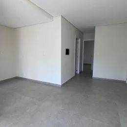 Vista interna de um cômodo com piso cinza e paredes brancas.