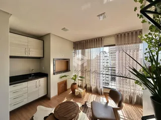Sala de estar com piso de madeira e grande janela com vista.
