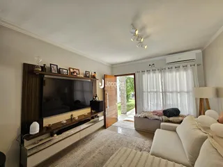 Sala de estar com sofá e painel de TV em um apartamento no Brasil.